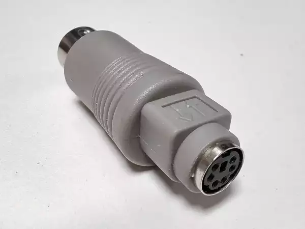 A photo of a passive 6-pin Mini-DIN to 5-pin 180° DIN adapter from its female PS/2 end